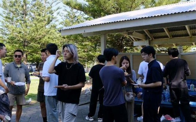 AWS UNSW members gathered around a barbecue in a park